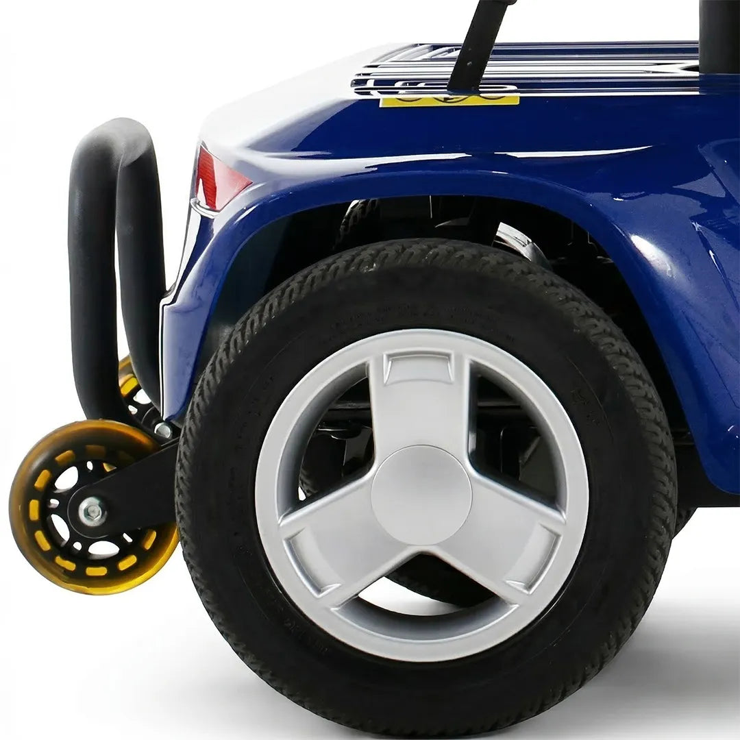 Primer plano detallado de la rueda trasera de un scooter de movilidad lucas pro, mostrando la llanta plateada, el neumático con dibujo y el sistema de ruedas antivuelco dortomedical