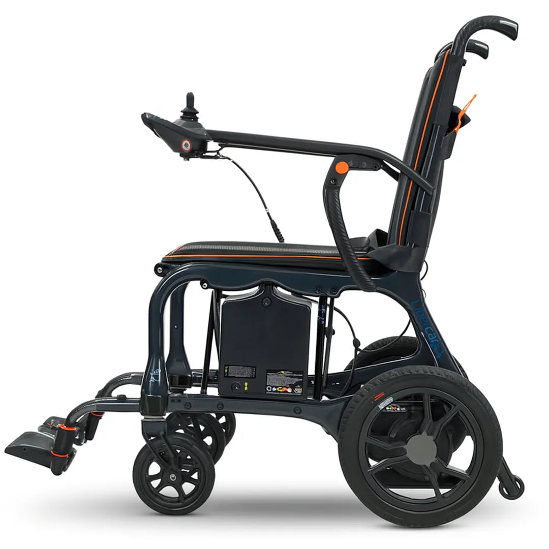 Vista lateral de la silla eléctrica que muestra el joystick extraíble con sistema quick release y los reposabrazos abatibles para transferencias cómodas dortomedical