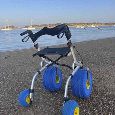 Vista trasera del andador para playa con asiento y ruedas anchas diseñado para desplazarse por la arena dortomedical