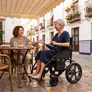 Usuaria llegando a una cafetería donde le espera una amiga, utilizando la silla de ruedas eléctrica SIRA con llantas de aluminio dortomedical