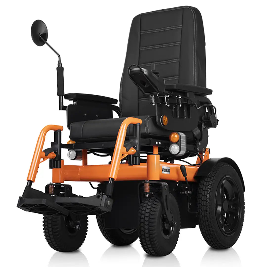 Ángulo de la silla eléctrica mostrando el asiento con acolchado confortable, reposabrazos fijos inyectados y reposapiés plegables para facilitar el acceso dortomedical