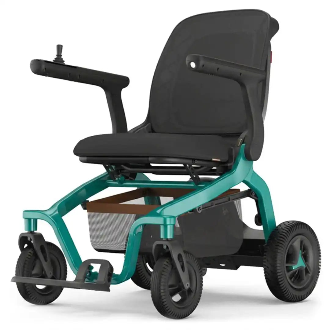 Vista en ángulo de la silla eléctrica mostrando el asiento y respaldo de espuma transpirable con reposabrazos abatibles para facilitar el acceso dortomedical