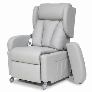 Vista frontal del sillón con el reposabrazos extraído y apoyado en el suelo, mostrando cómo se libera el lateral para realizar transferencias cómodas a sillas de ruedas o camas dortomedical