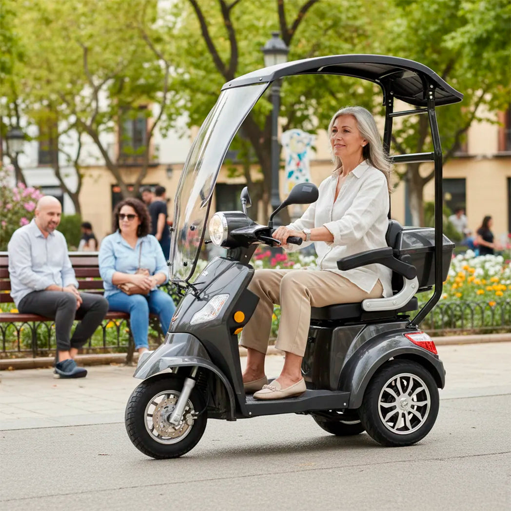 Persona mayor conduciendo scooter eléctrico con techo en exterior, demostrando comodidad y protección climática dortomedical